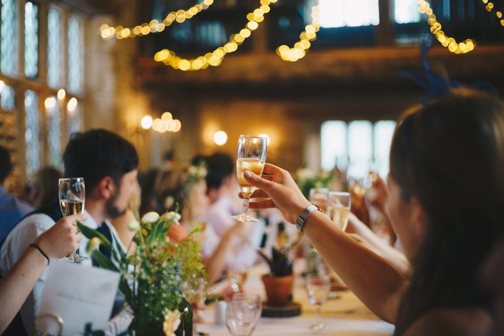 Photo représentant une groupe de personne attablée levant leur verre de champagne